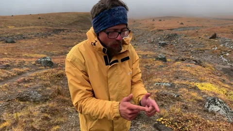 A crazy tourist in a yellow jacket is looking for water in Kamchatka Stock-Footage 145185033