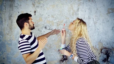 Crazy young dancing pair having fun making bubbles listening to music in love Stock Footage 73130687