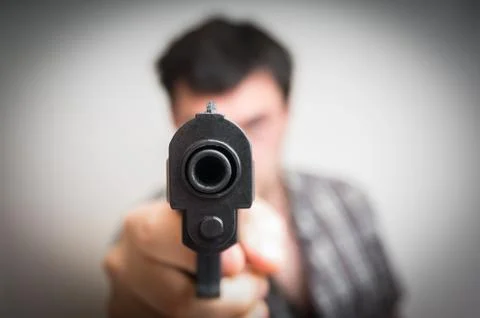 Crazy young man aiming automatic gun at you Stock Photos