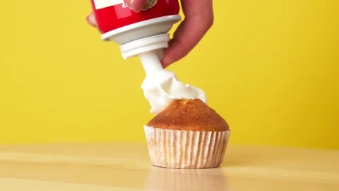 Cream is Applied to the Cake. Baking Dessert on a Yellow background rotates Video stock 202650681