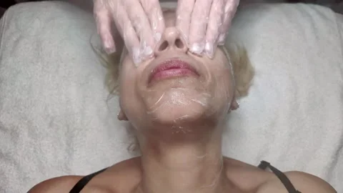 Cream Being Applied and Rubbed on Woman Face in Beauty Salon Stock Footage 300132847