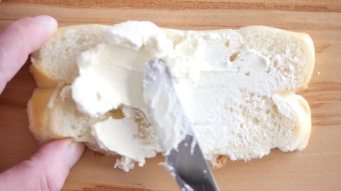 Cream cheese spreading on bread Stock Footage 88411876