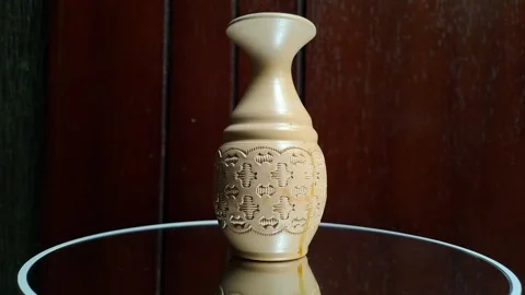 A cream-colored mini ceramic vase featuring a central ornament Stock Footage 341308159