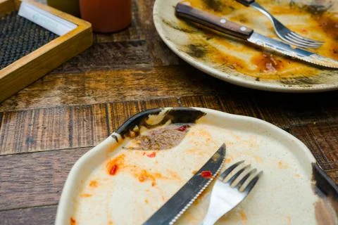 A cream-colored plate with a beautiful pattern shows leftover food, includi.. Stock Photos