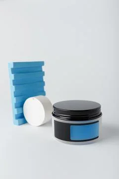 Cream container with empty blue label, mock up template on white background Stock Photos