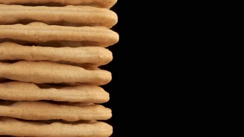 Cream cracker stacked close up isolated against black background stock footag Stock Footage 220454968