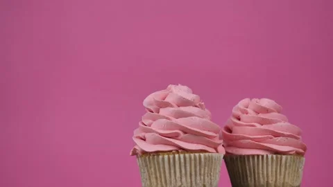 Cream cupcakes rotate on a pink background. Sweets and desserts for birthday Stock Footage 274676489