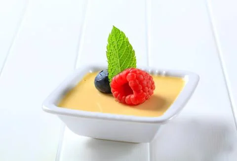 Cream dessert with raspberry and mint garnish Stock Photos