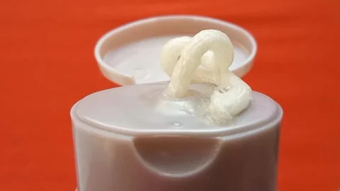 Cream face wash texture squeezed out of a tube on an orange background, closeup. Stock Footage 320861243