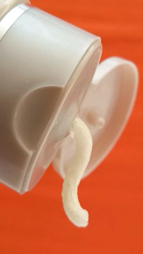 Cream face wash texture squeezed out of a tube on an orange background, closeup. Stock Footage 320861258