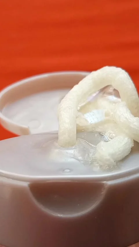 Cream face wash texture squeezed out of a tube on an orange background, closeup. Stock-Footage 320861274