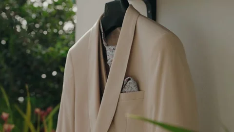 Cream Groom Jacket With Patterned Pocket Square Hanging Outdoors Stock Footage 343705524