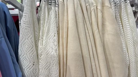 Cream Knit Sweaters and Cardigans Displayed in Modern Fashion Store Video stock 336320085