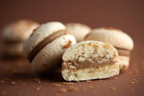 Cream macarons close-up on brown background Stock Photos