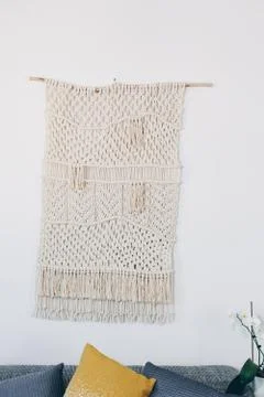 Cream macrame decor displayed hanging on a wall. Foto stock
