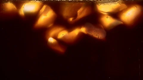 Cream or milk is poured into an iced coffee, frappe, frappuccino, ice coffee. Ma Stock Footage 128657169