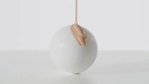 Cream paint falling onto a white ball Stock Footage 260344876
