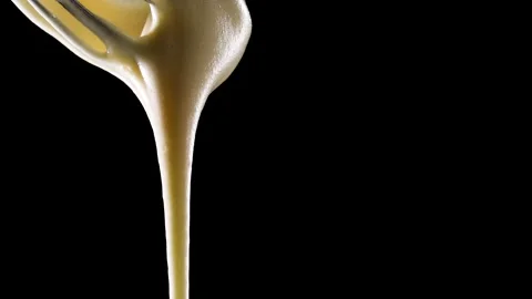Cream is poured on a black background Stock Footage 150776311