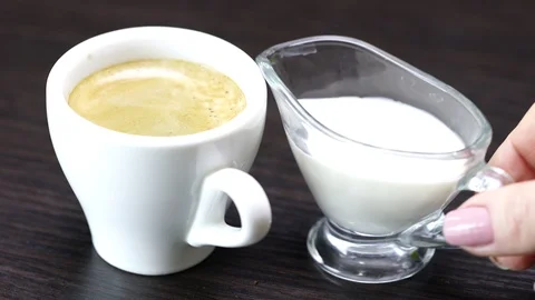Cream is poured into a cup with hot coffee Stock Footage 120575955