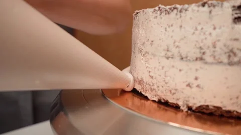 Cream put on board the cake with the help of a confectionery package and a Stock Footage 155450652