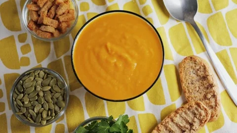 Cream of roasted pumpkin soup with bread, seed pumpkin, herbs, rusks, ready Video stock 326199115