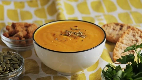 Cream of roasted pumpkin soup with bread, seed pumpkin, herbs, rusks, ready Video stock 326199274