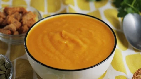 Cream of roasted pumpkin soup with bread, seed pumpkin, herbs, rusks, ready Video stock 329275860