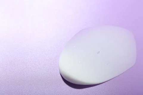 Cream sample on violet background, closeup. Space for text Stock Photos