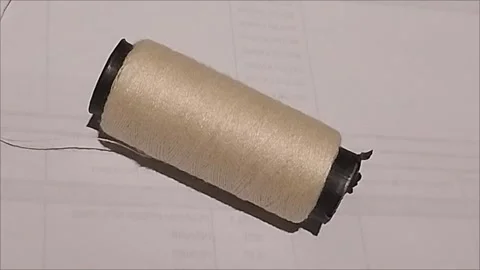 Cream Sewing Thread Spool Lying on White Background Stock Footage 296978552