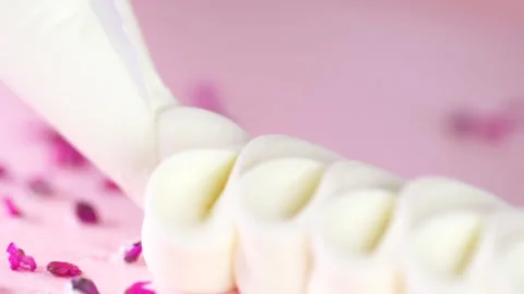Cream squeezing out for a pink dessert. Stock Footage 141522909