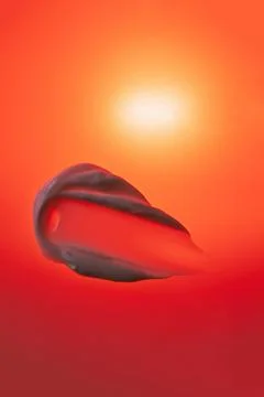Cream texture on a red background with sun. Stock Photos
