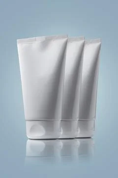 Cream tubes on light blue background. Stock Photos