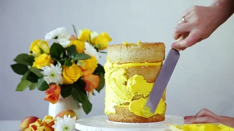 Creaming the multi-layered cake with yellow cream using confectionery spatula. Stock Footage 102043020