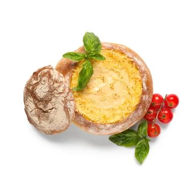 Creamy cheese soup in rustic bread bowl with fresh basil and cherry tomatoes, 库存照片