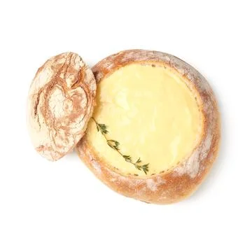 Creamy cheese soup in rustic bread bowl with fresh thyme garnish delicious ap 库存照片