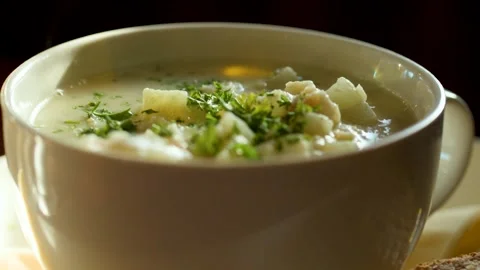 Creamy Chowder in White Bowl with Rustic Bread Slice Stock Footage 318433654