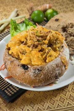 Creamy curry served in rustic bread bowl Stock Photos