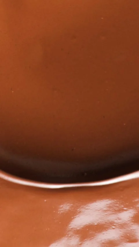 Creamy liquid chocolate surface flowing for confectionery advertising background Stock Footage 346686730