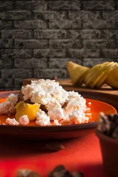 Creamy rice pudding with fruit on a dark plate in a rustic setting Stock Photos