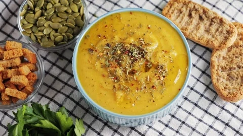 Creamy vegetable soup with bread, pumpkin seeds, herbs and croutons. Homemade Video stock 331564126