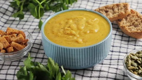 Creamy vegetable soup with bread, seed pumpkin, herbs, rusks. Table served with Video stock 316895003