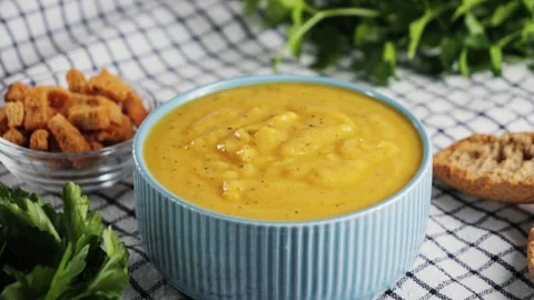 Creamy vegetable soup with bread, seed pumpkin, herbs, rusks. Table served with Video stock 326199053
