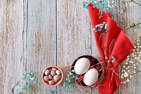 Create an Easter composition of Easter quail eggs and flowers on a wooden b.. Stock Photos