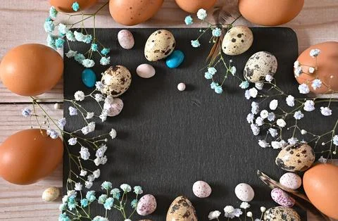 Create an Easter composition of Easter quail eggs and flowers on a white wo.. Stock Photos