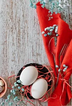 Create an Easter composition of Easter quail eggs and flowers on a wooden b.. Stock Photos