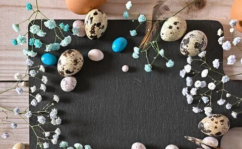 Create an Easter composition of Easter quail eggs and flowers on a white wo.. Stock Photos