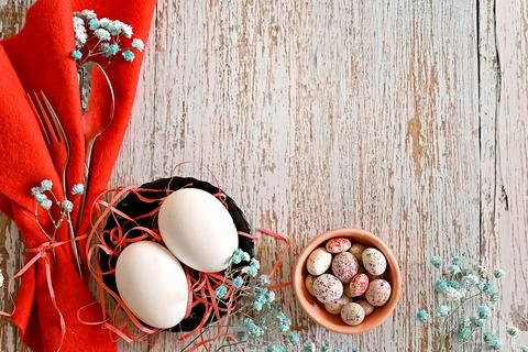 Create an Easter composition of Easter quail eggs and flowers on a wooden b.. Stock Photos