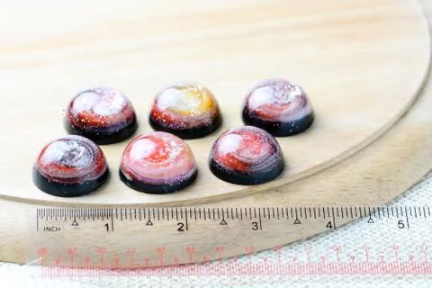 Create galaxy drink coasters using resin, glitter and pigment powders, handma Stock Photos