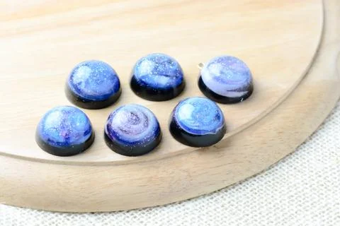 Create galaxy drink coasters using resin, glitter and pigment powders, handma Stock Photos