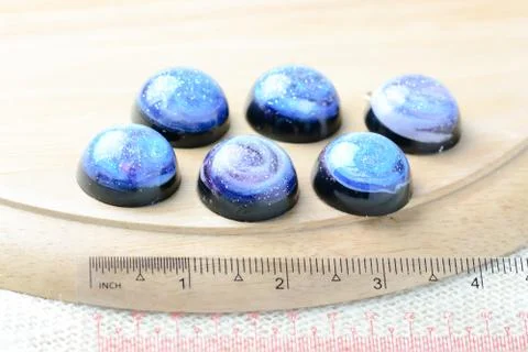 Create galaxy drink coasters using resin, glitter and pigment powders, handma Stock Photos